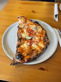 Enjoy authentic Neapolitan pizza and calzone at Figli Del Vesuvio