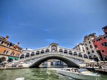 Cross the canal on the Rialto bridge