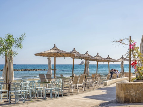 Sit beneath thatched parasols with the Mediterranean at your feet