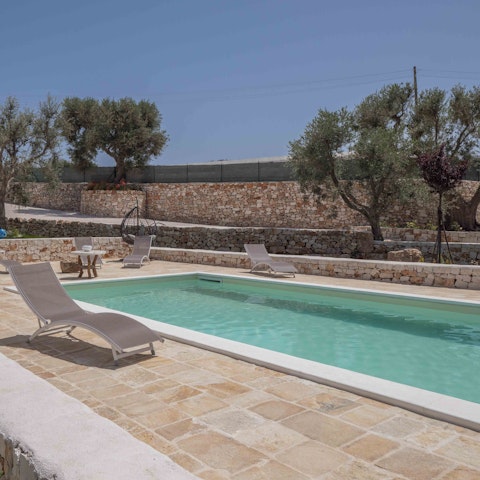 Relax on a lounger by the private pool