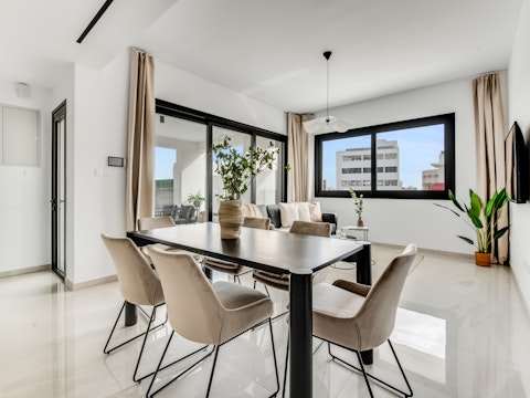 Pull up a chair at the dining table, framed by sweeping city rooftop views