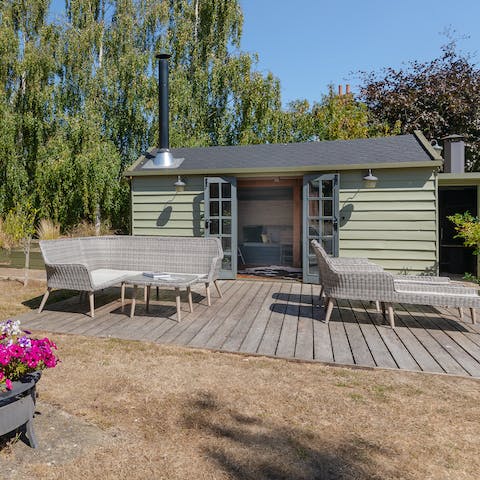 Relax in the stunning summer house complete with log burner and dining table