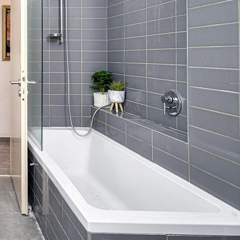 Treat yourself to an indulgent bubble bath in the sleek bathroom