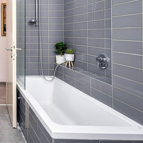 Treat yourself to an indulgent bubble bath in the sleek bathroom