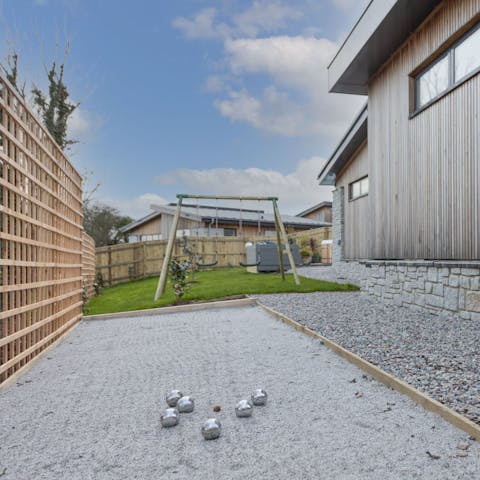 Get competitive with a game of boules while kids play on the swing set