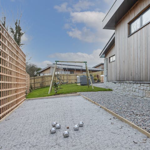 Get competitive with a game of boules while kids play on the swing set
