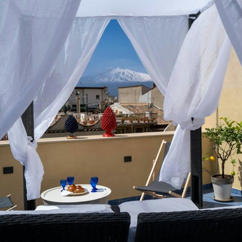 Enjoy cocktails on the terrace with views of Mount Etna