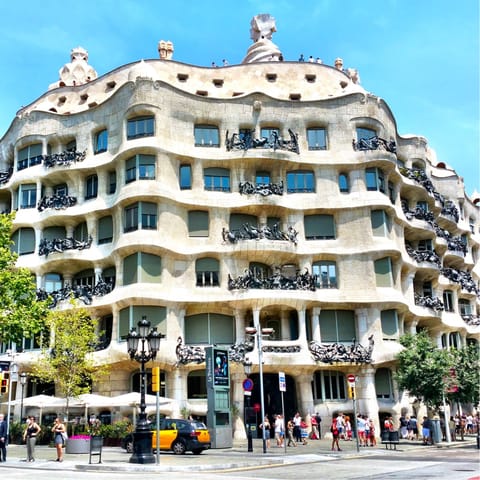 Admire the limestone facade of Casa Milà, a twelve-minute stroll from home