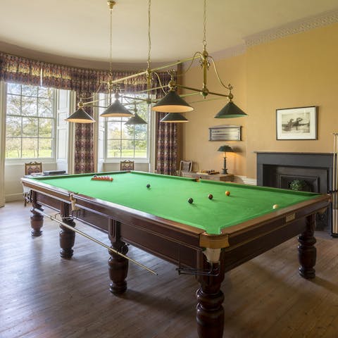Play a game of pool on the table
