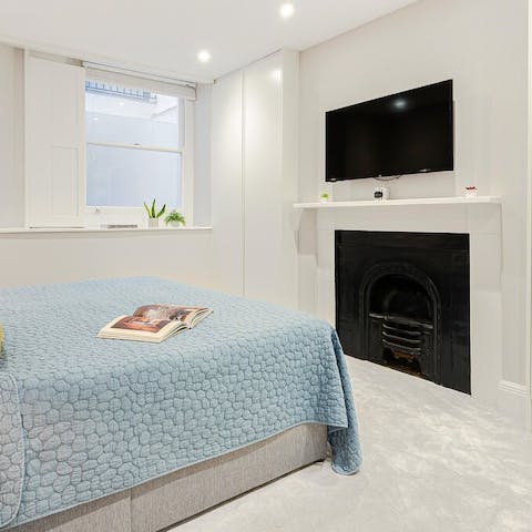 Admire the original fireplace in the plush main bedroom