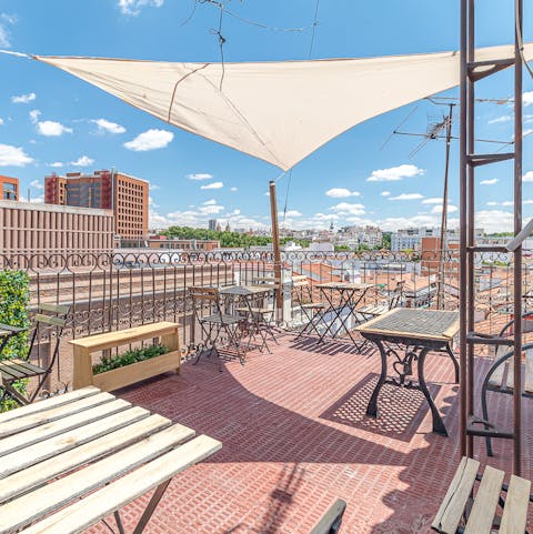 Enjoy a glass of wine on the shared rooftop terrace at sunset