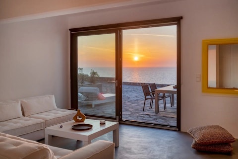 Watch the sun melt into the Aegean from the sofa