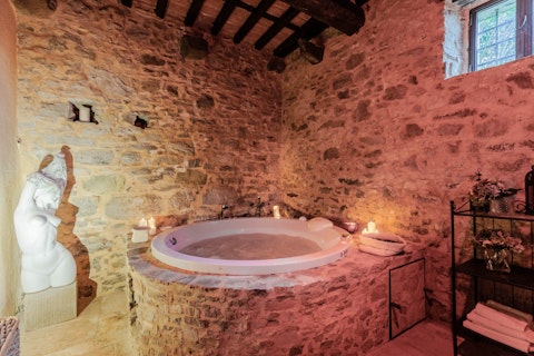 Unwind in the ancient stone bathroom by candlelight