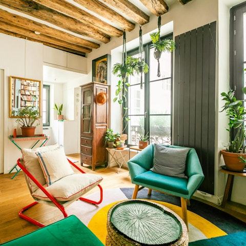 Curl up with a glass of wine amid plants and pretty furnishings