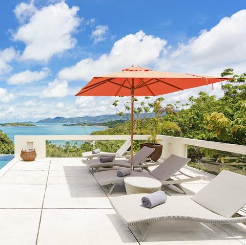 Relax and recline on a poolside lounger with a cocktail in hand