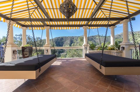 The swinging daybeds under the canopy