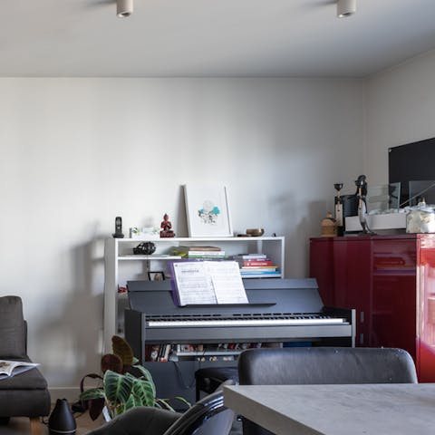 Play a tune on the piano in the eclectic living space