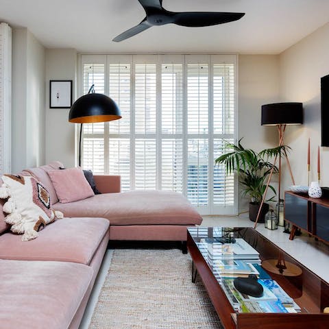 Relax on the pink sectional with a glass of wine – courtesy of the wine fridge – after a day of touring the city