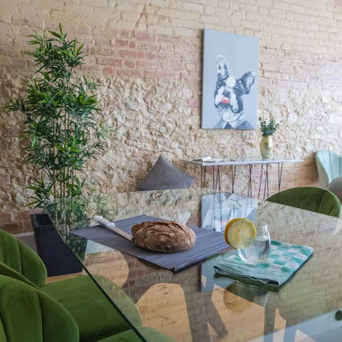 Come together around the glass dining table with green velvet chairs for a G&T