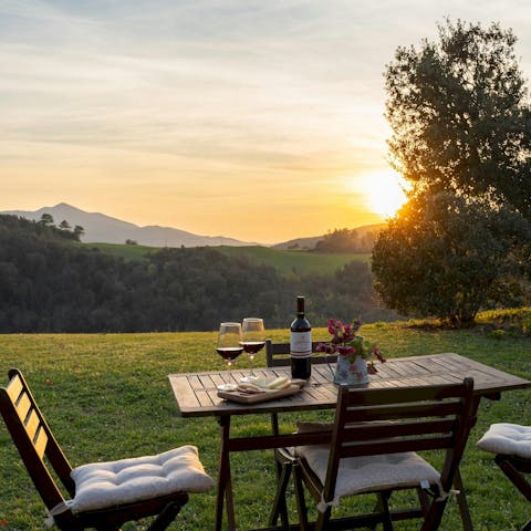 Sip local wine as the sun sets behind the hills