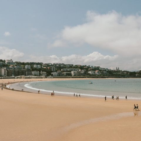 Sink your toes into the sandy beach of La Concha, a two-minute walk from your home