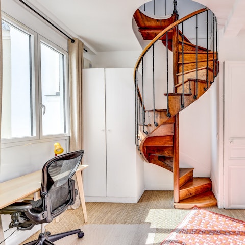Catch up on work or get inspired to create at the work desk, beside an opulent winding staircase