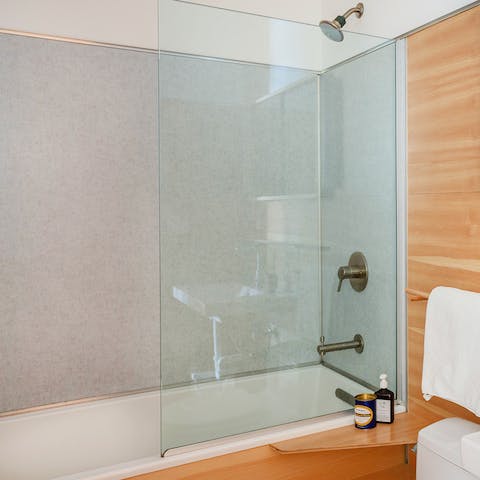 Take a long soak in the calming natural stone and wood bathroom