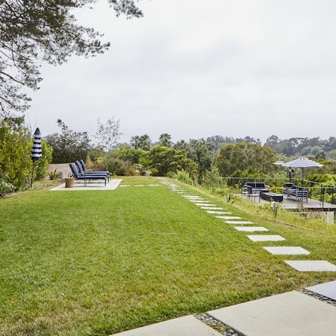 Relax in the lush back garden with its sun loungers and outdoor sofas