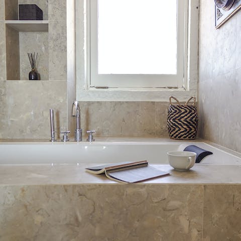 Soak in the relaxed opulence of this home with a bath in the marble tub