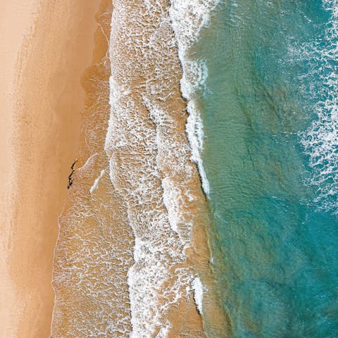 Sink into the soft sand of Mannera Beach, mere footsteps away