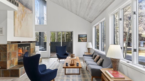 Warm up by the fire as aspen trees frame the windows