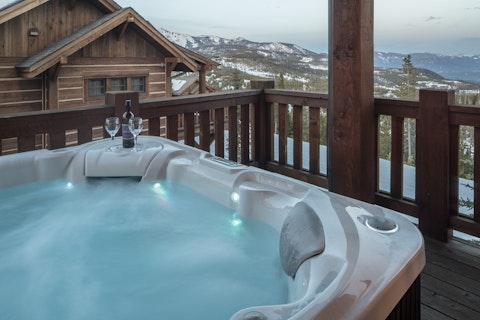 Soak in the outdoor hot tub with snow-dusted mountain peaks ahead