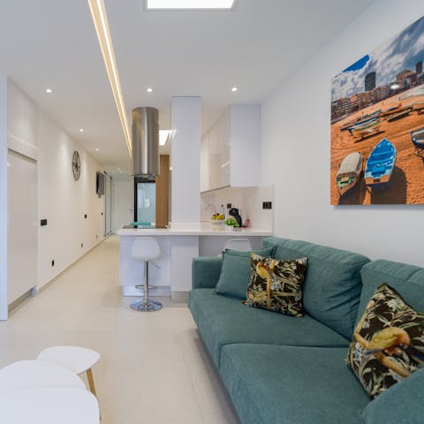 Come home and relax on the cosy turquoise-coloured sofa with a glass of Spanish wine