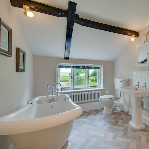 Soak up the views through the 16th century mullion window from the rolltop bath