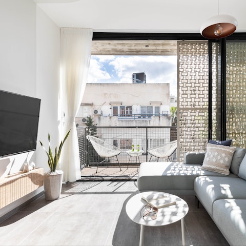 Settle in for a cosy evening of movies and wine in the bright and stylish living area