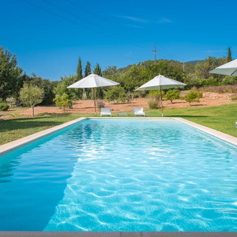 Cool off from the Ibizan sun in the private pool surrounded by a lawn and trees
