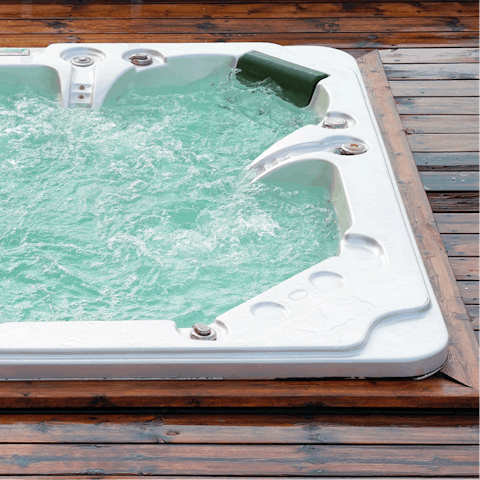 Unwind in the private hot tub, looking out at the rolling scenery