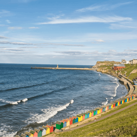 Stroll to West Cliff Beach to skim stones and check out the colourful beach huts