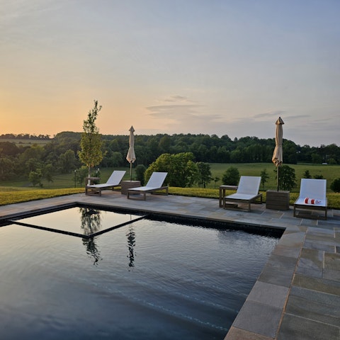 Laze around the pool during sunset with a drink in hand