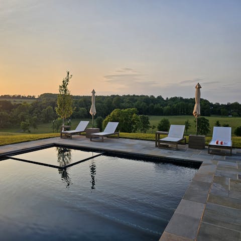 Laze around the pool during sunset with a drink in hand