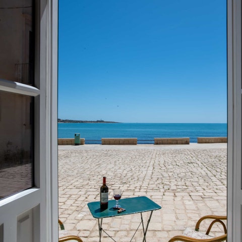 Share a bottle of wine and admire the sea views