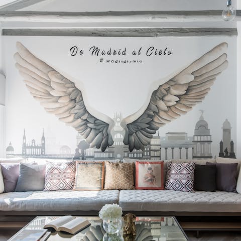 Squeeze everybody in on the long sofa underneath the mural and settle in for movie night