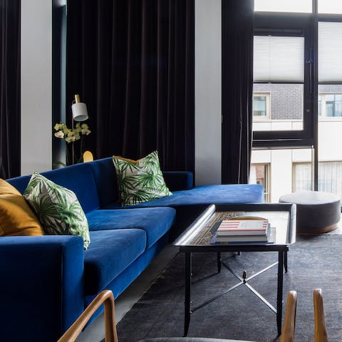 Pour a glass of wine and recline in style on the blue velvet sofa
