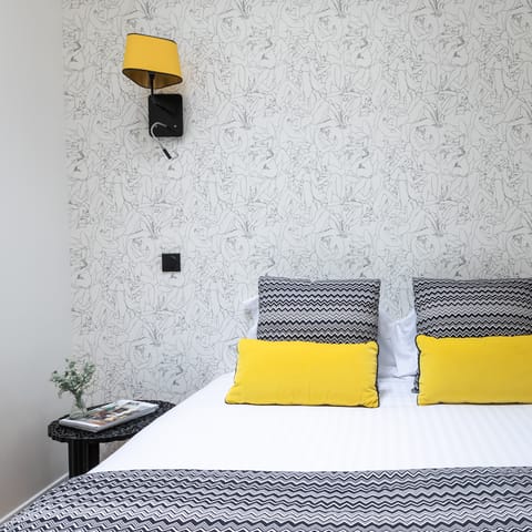 Nod off under stylish wallpaper in the comfy bedroom