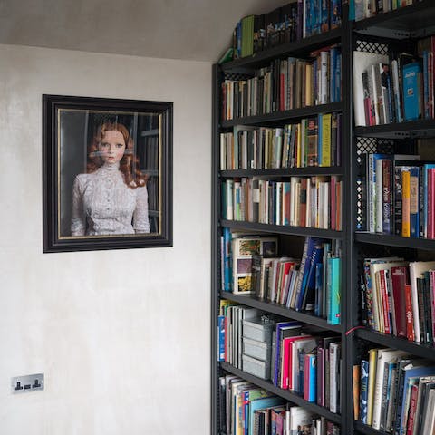 Peruse the packed bookshelves and read on the chaise longue