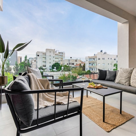 Ease into the sofa with city views stretching beyond the balcony