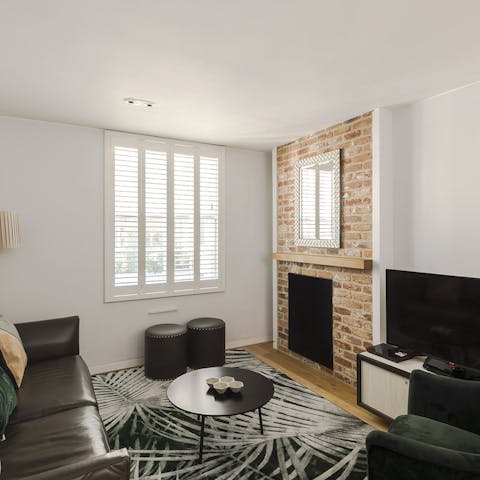 Relax in the living area after a long day, admiring the exposed brick wall