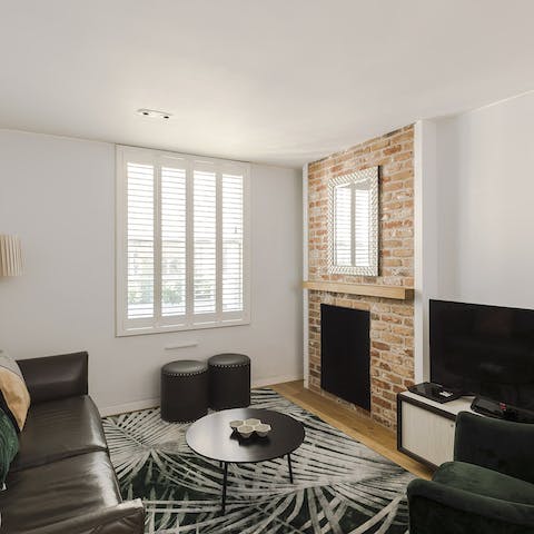 Relax in the living area after a long day, admiring the exposed brick wall