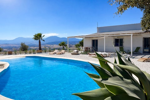 Plunge into cool water with Andalusian mountains stretching beyond