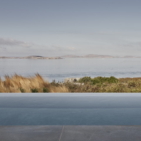 Take in the stunning views of the island of Delos from the infinity pool